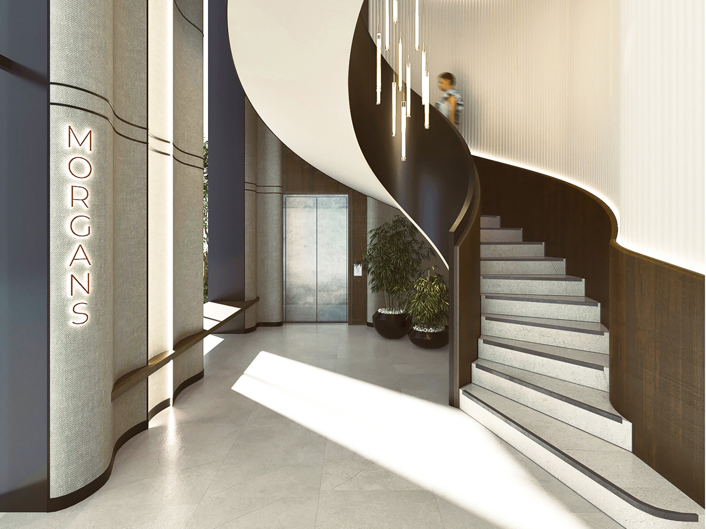 Entrance lobby with a sweeping staircase, pendant lights and planting.