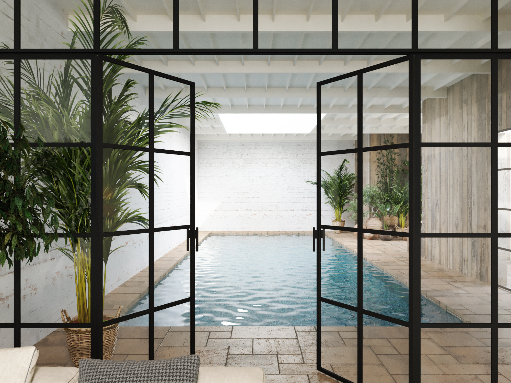 Indoor pool seen through steel-framed doors, among palms and whitewashed walls.