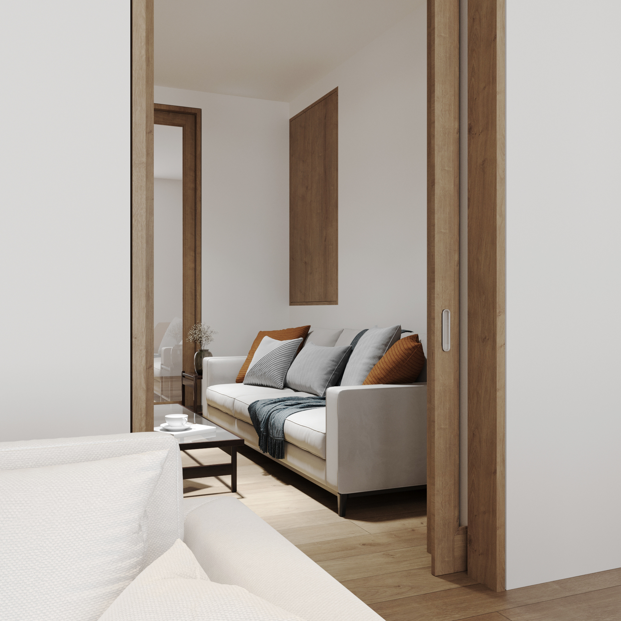 Sitting area seen through a timber-framed opening, with a grey sofa and cushions.