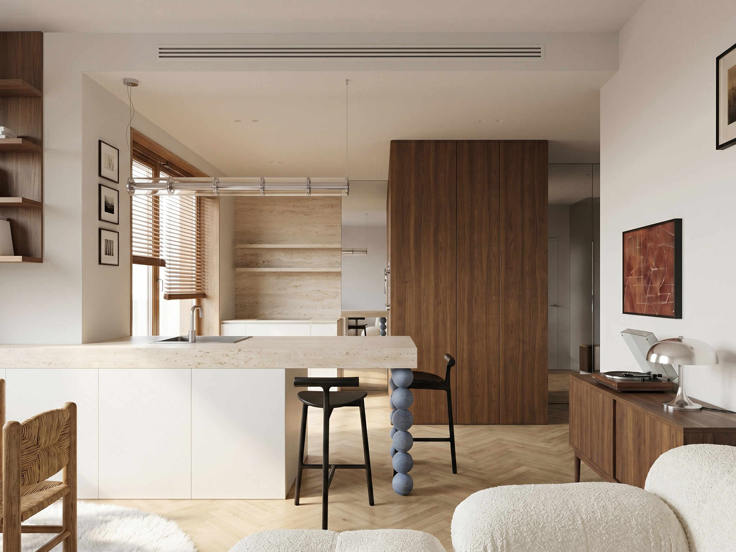 Open-plan kitchen with a pale stone island, dark bar stools, walnut tall units and the dining area beyond.